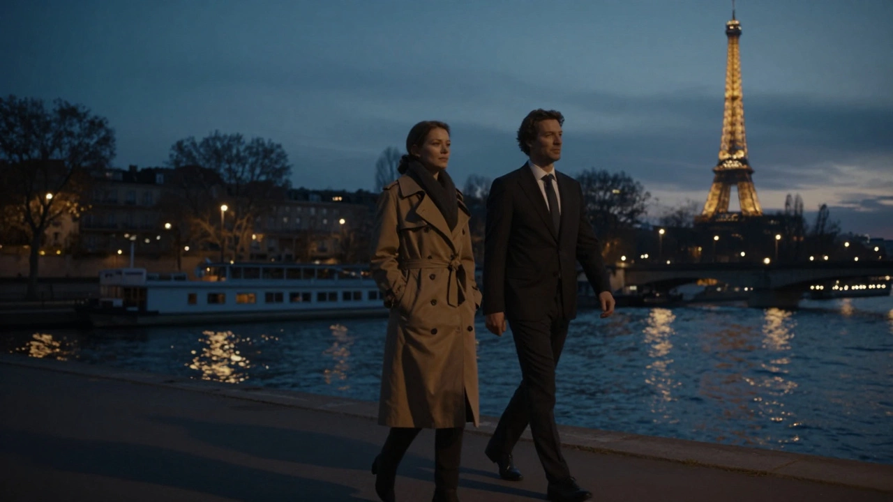 Silhouettes of a man and woman walk along the Seine at dusk, the Eiffel Tower glowing faintly behind them.